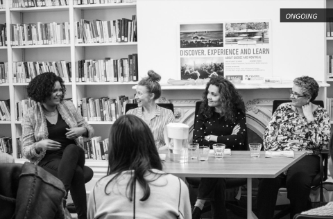 CIRM event in black and white. Panelists discussing in front of a bookshelf.