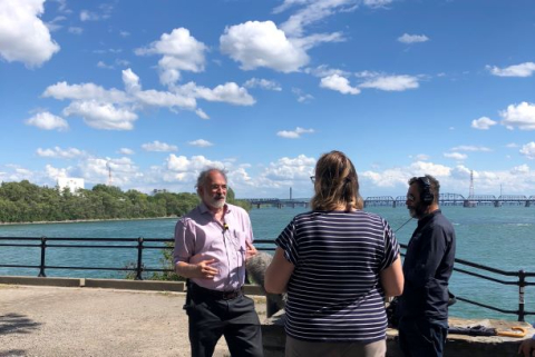 Group of panelists talking in front of the St. Lawrence river, on a sunny afternoon.