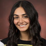 girl posing for camera in her graduate gown