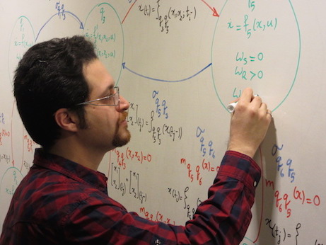 Presenter writes equations on whiteboard