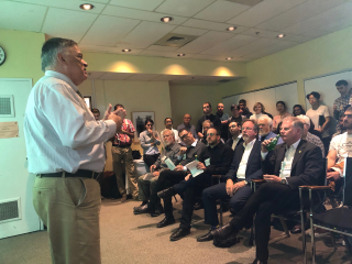 man presenting in front of a crowd indoors