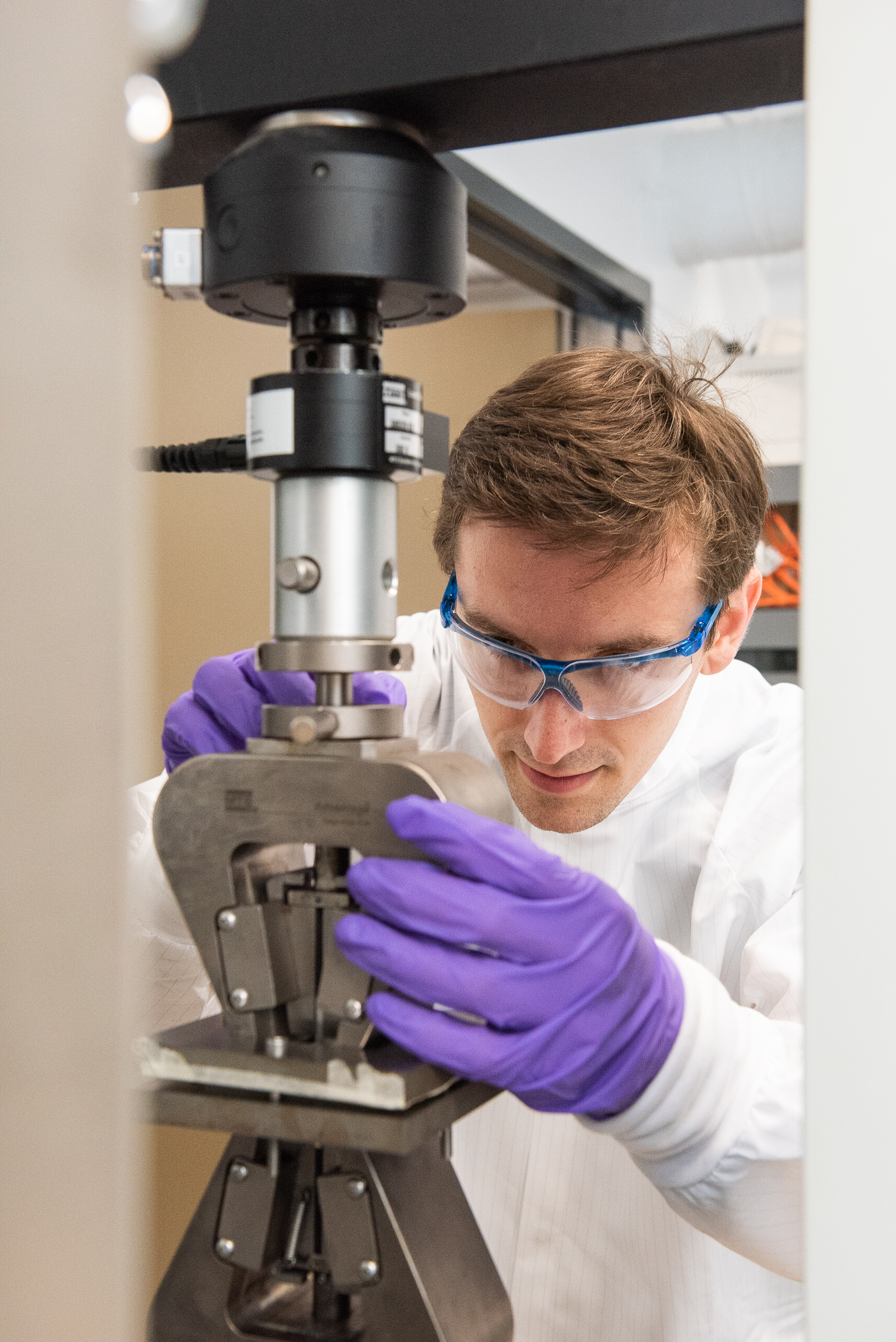 Young man loading a sample in a 5kN tensile machine