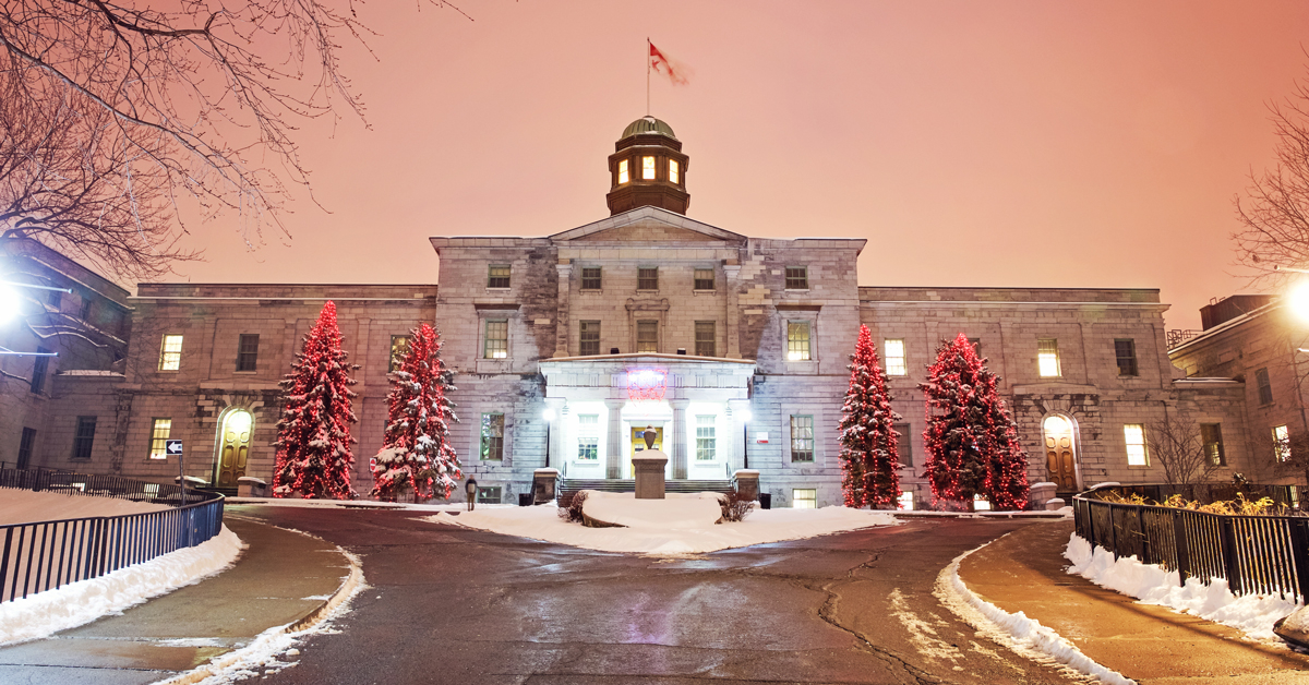 Photograph of McGill University main building with Christmas trees and fairy lights at the front