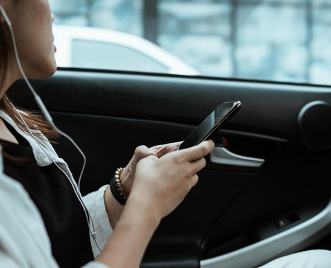 Person using cell phone while traveling by car