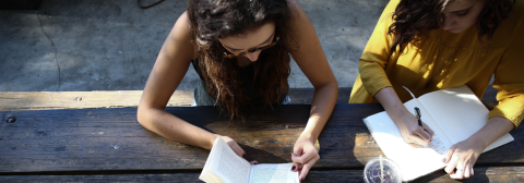 Two students writing in notebooks