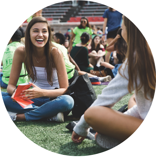 Students sitting on a field during Discover McGill