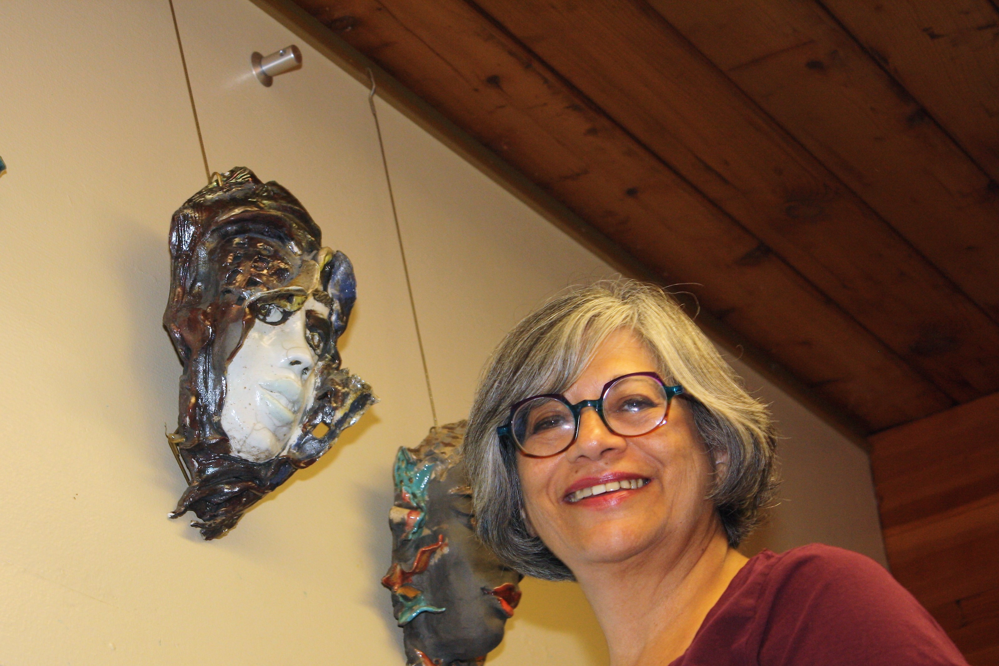 Shaheen Shariff with two artistic masks she made