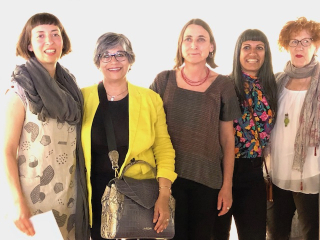 Groups of five females are standing to take a picture. Dr.Shariff wearing yellow jacket in standing on right