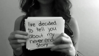 amanda todd holding a sign: "i've decided to tell you about my never ending story"