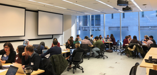 people sitting in groups in a classroom discussing