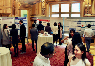 People mingling at an acadmic conference in front of research posters