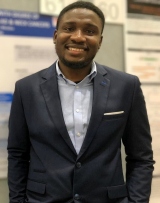 man in front of posters at conference