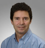 Close-up studio portrait of a man wearing a blue shirt