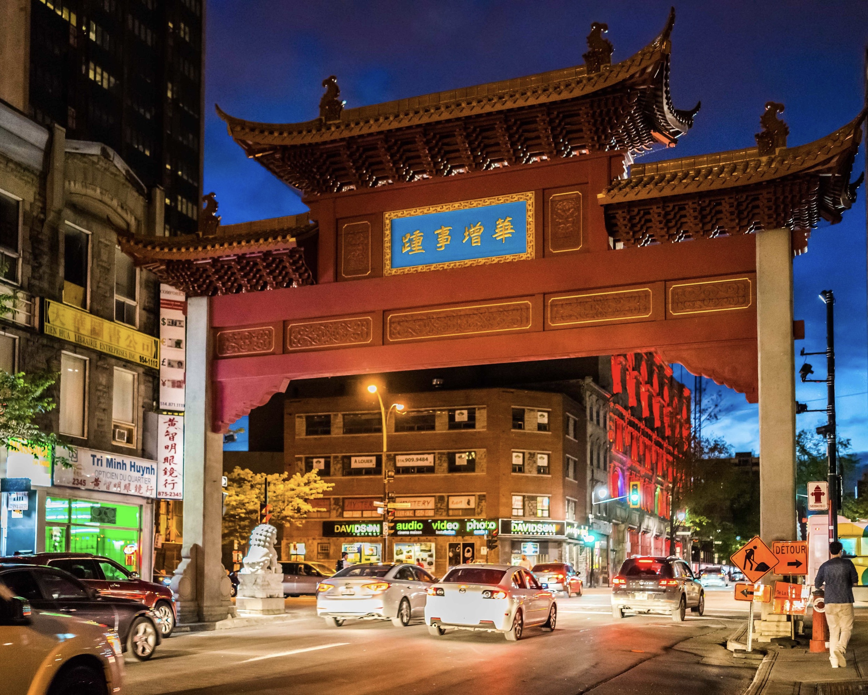 Montreals colourful Chinatown entrance illuminated by cars and streetlights at night