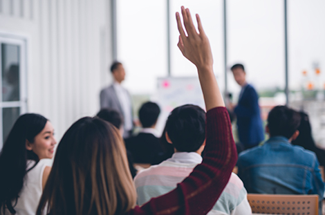 Female raising hand in a group setting