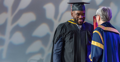 Graduate crossing stage at convocation ceremony