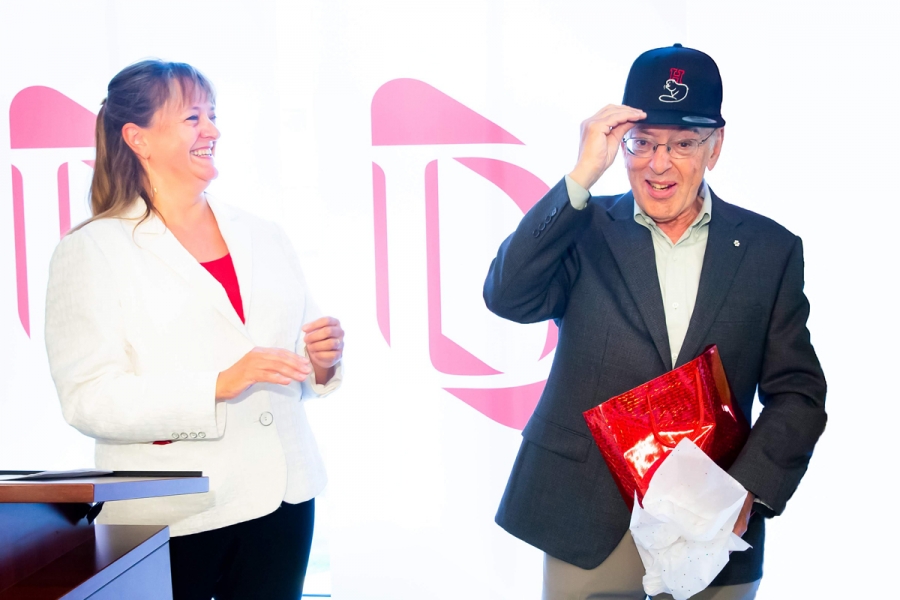 Dean Isabelle Bajeux-Besnainou presents Henry Mintzberg with a cap as a gift.