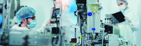 Individuals working in a lab using high tech machinery