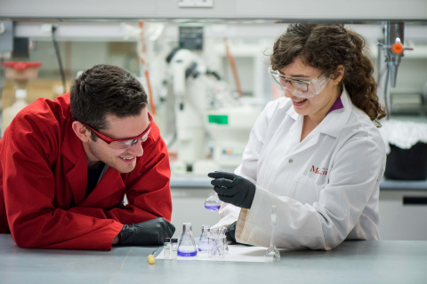 two scientists in a lab smiling