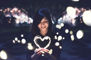 Student holding heart made out of lights