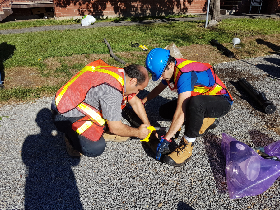 Two workers installing sensors on gravel