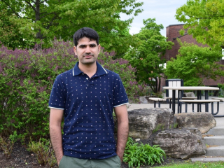 Naseer Hussain, post-doctoral researcher on the AGGP stands outside, 2019