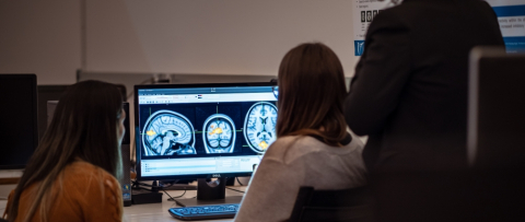 two girls looking at the screen with images of brain
