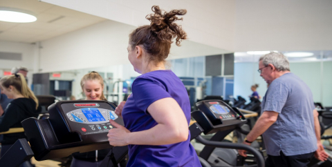 lady and a gentlemen running on tow different treadmills