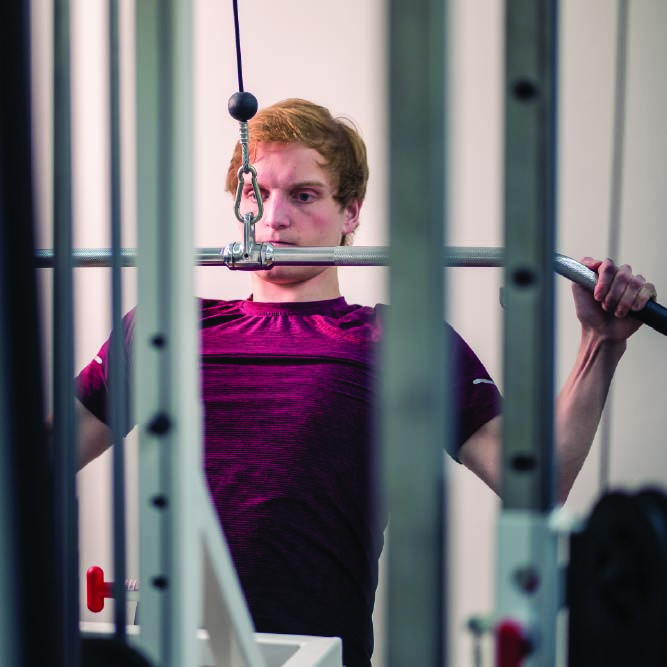 Student using weights machine