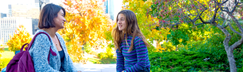 Two Women Talking in Front of the Education Building