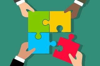 Image of different people making a puzzle together