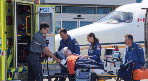 Air ambulance paramedics transferring a patient to a land ambulance