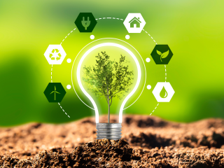 Lightbulb with six hexagons around it. The hexagons contain a windmill, recycling symbol, electrical plug, house leaf, water droplet.  