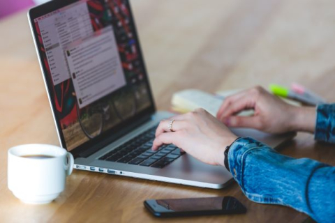 Person writing on a laptop