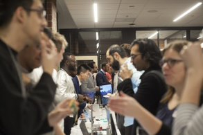 Photo of students presenting their projects during an event and speaking with attendees. 