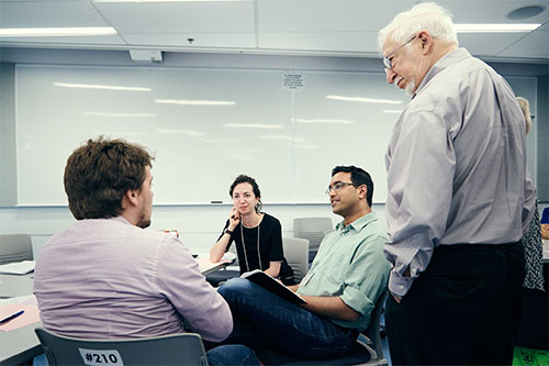 4 people having a conversation in a classroom