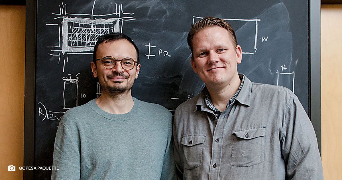 Professor Salmaan Craig (left) and Professor Kiel Moe (right) smiling in front of a blackboard