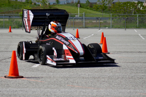 A race car being driven between small cones