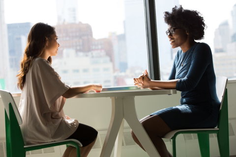 2 women sitting face to face and chatting 