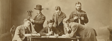 6 students of the first Class of McGill Faculty of Engineering working around a table with tools and machines (vintage)