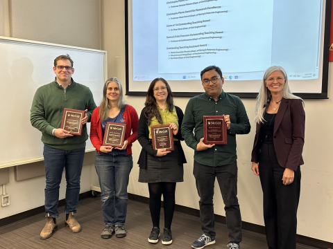 Award recipients stand holding their awards with Dean Yargeau