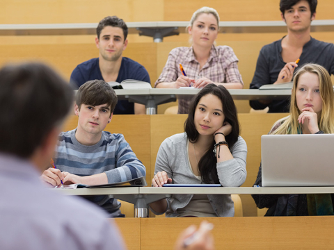 A group of students attentively listening to speaker in an auditorium