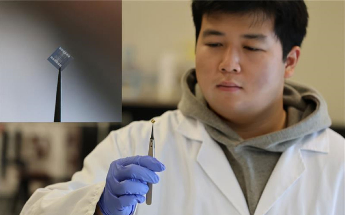 a student holding up a chip in a lab