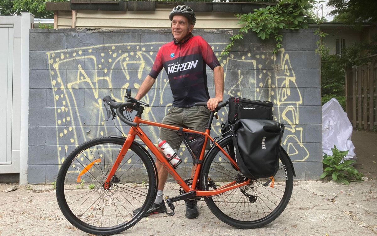 Prof. Larry Lessard standing next to his bike