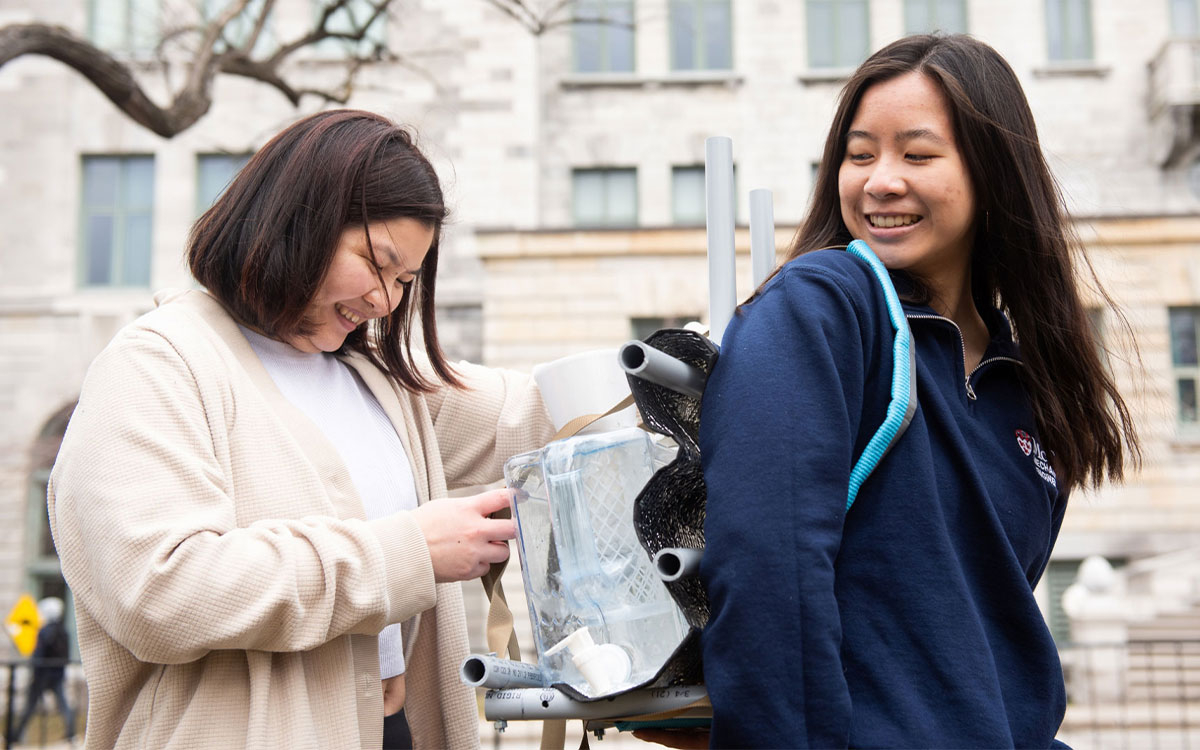 Bernadette Ng and Tirza Pang testing water-filtering backpack