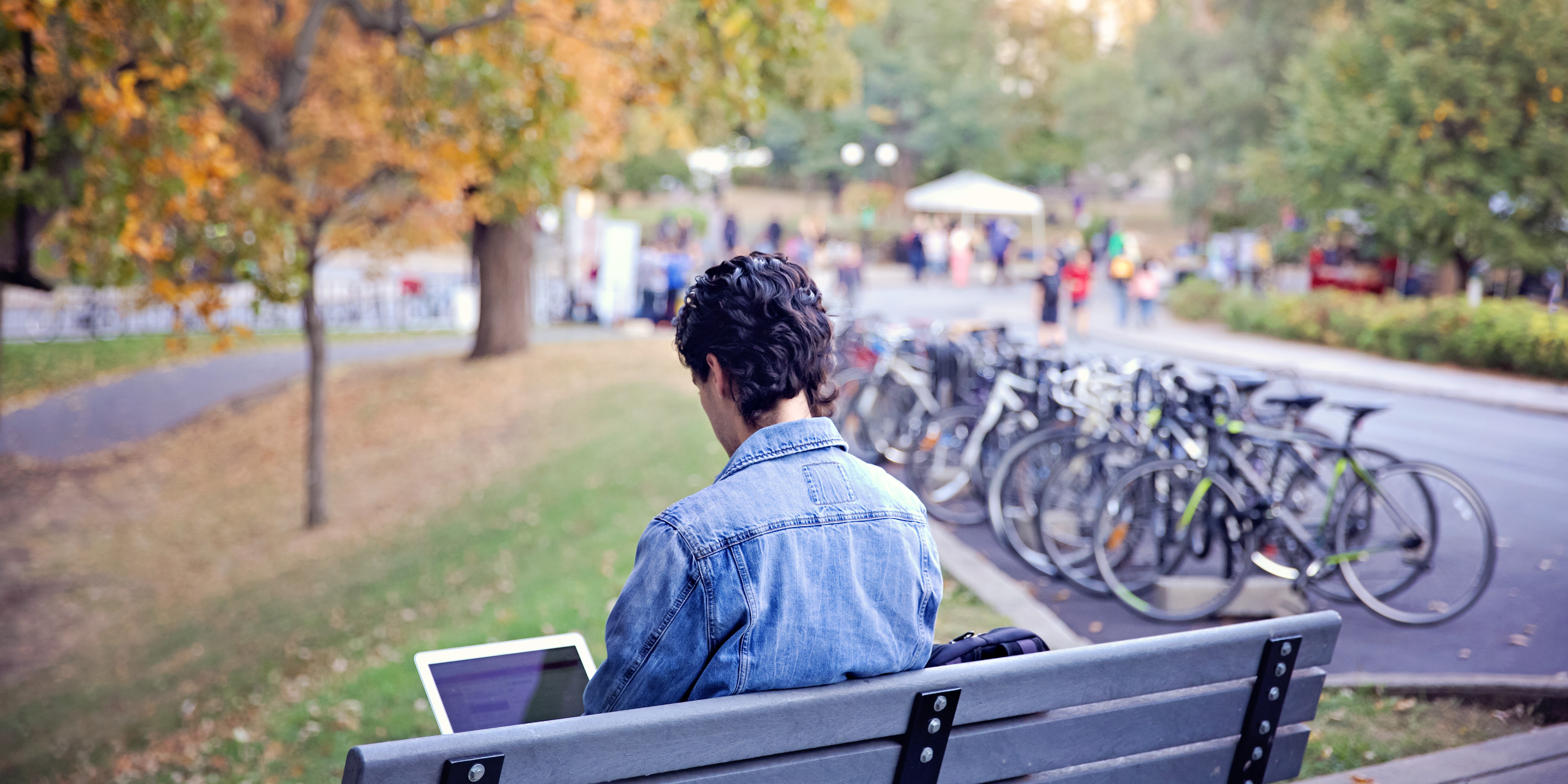 Person sitting on a bench using laptop