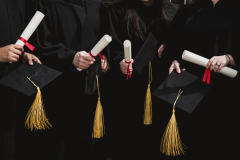 Students with graduation caps and diplomas