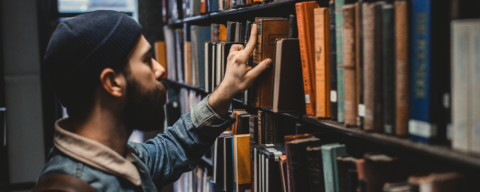 Homme parcourant une bibliothèque