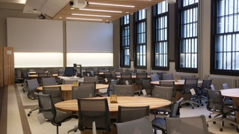 Conference room with office chairs surrounding several round tables