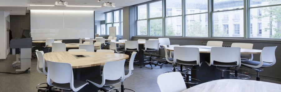 White round tables surrounded by white office chairs in a conference room
